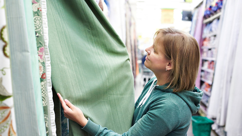 person choosing curtains in a store