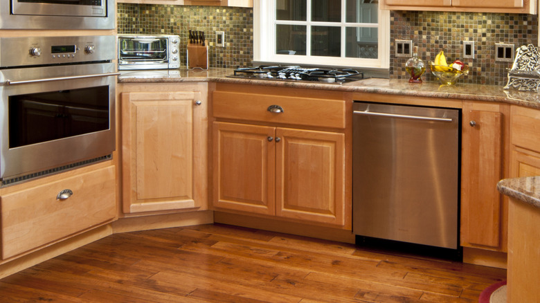 light wood lower cabinets including a corner cabinet door