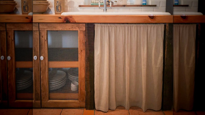 white curtain in place of a door on lower kitchen cabinet