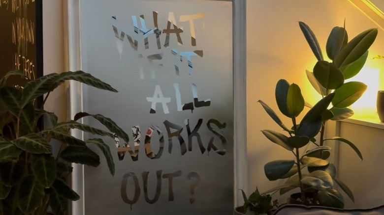 A large, foggy mirror leaning on the wall with a message