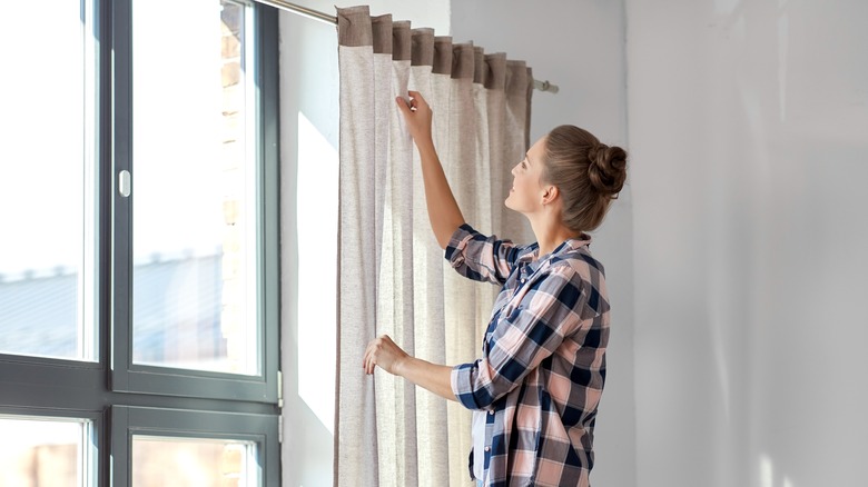 Woman hanging curtains