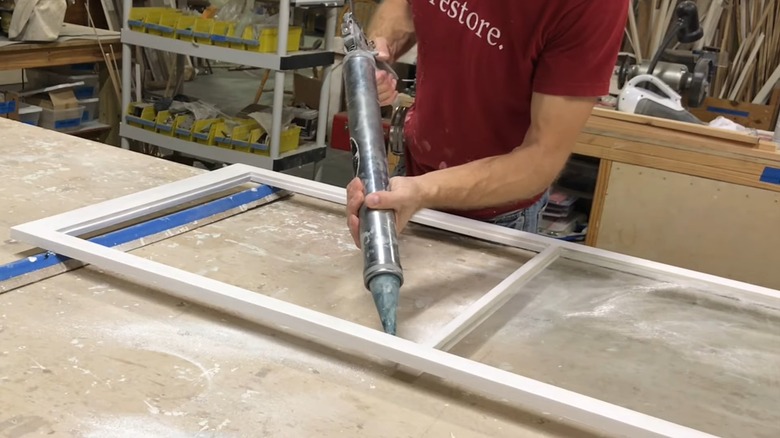 Man DIYing a storm window in his workshop