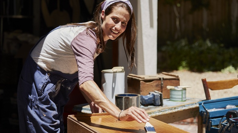 Lady varnishing a wood project