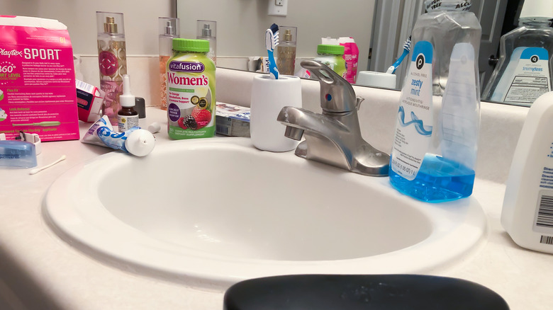 Cluttered bathroom sink and counter