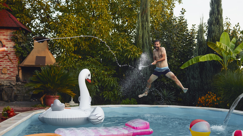 man playing with pool toys