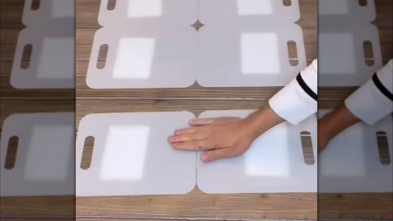 Person aligning cutting boards to make a clothes folding board