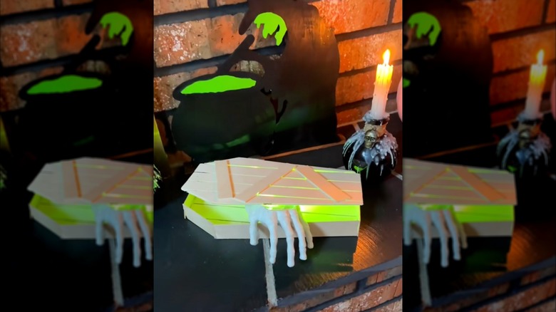 The DIY coffin with a plastic skeleton hand inside