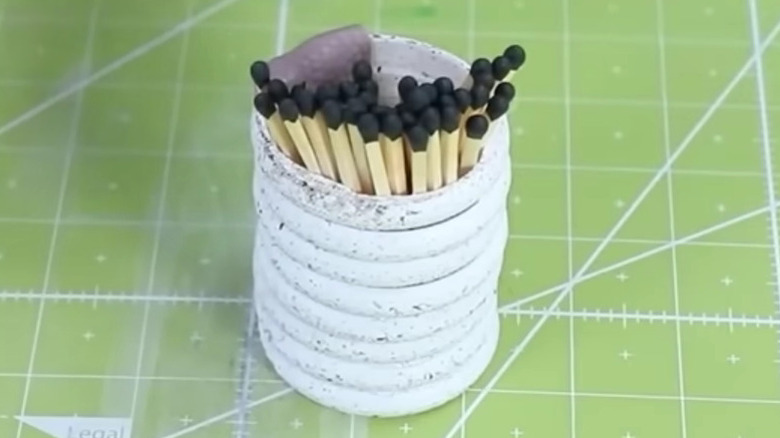DIY storage container made of stacked shower curtain rings with matchsticks inside
