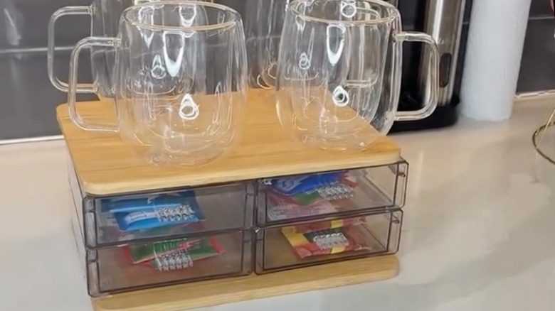 screenshot showing DIYed organizer with glass cups on top and small snacks in drawers