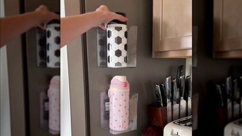 Person placing tumblers on Dollar Tree magnetic dryer sheet holder