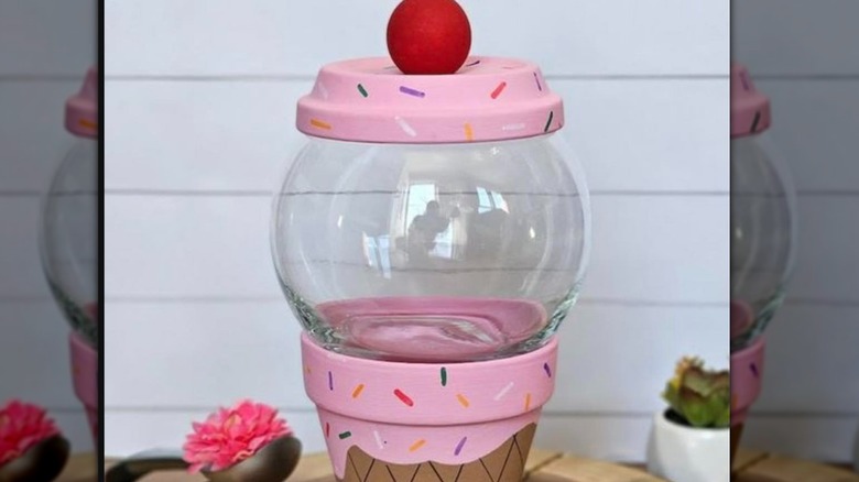 Colorful candy dish made to look like an ice cream cone with pink sprinkle covered top, red ball, and a "melting" ice cream on the cone