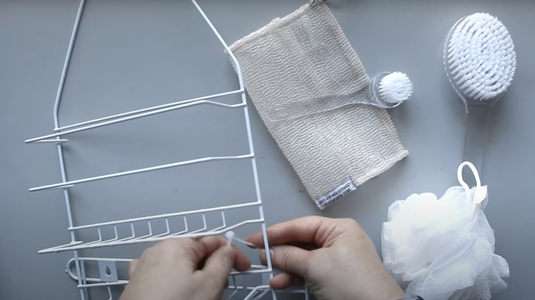An over-the-door hanger is zip tied to a wire caddy for shower supply storage.