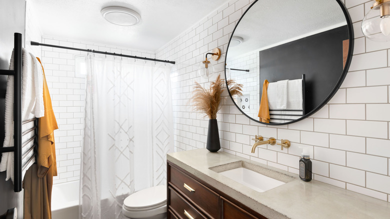 Bathroom vanity with a round mirror above it
