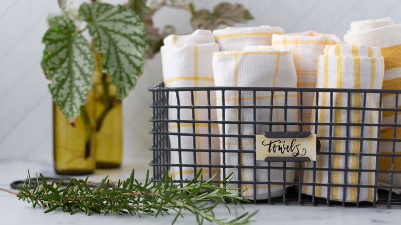 A wire basket being used to organize a bathroom shelf