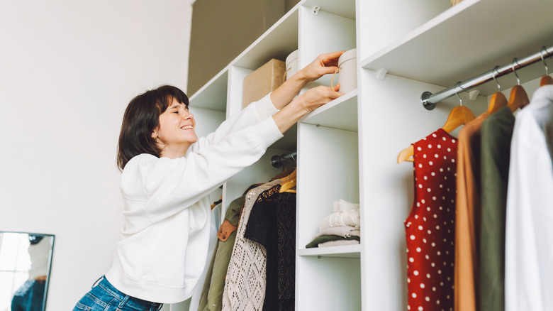 Person putting storage bins in a closet