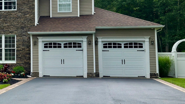 A stylish and modern-looking two-car gar garage prominently occupies the front facade of a new-build home located somewhere in the Eastern U.S.