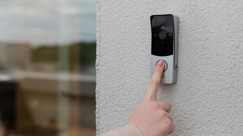 Person pushing a doorbell