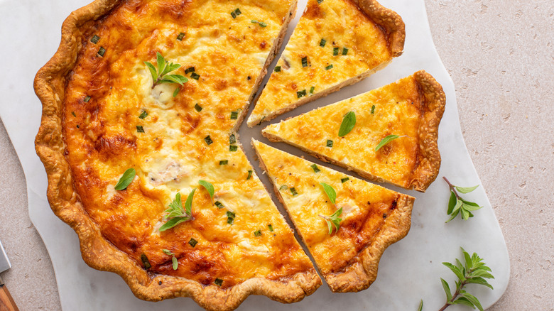 A sliced up quiche on a cutting board.