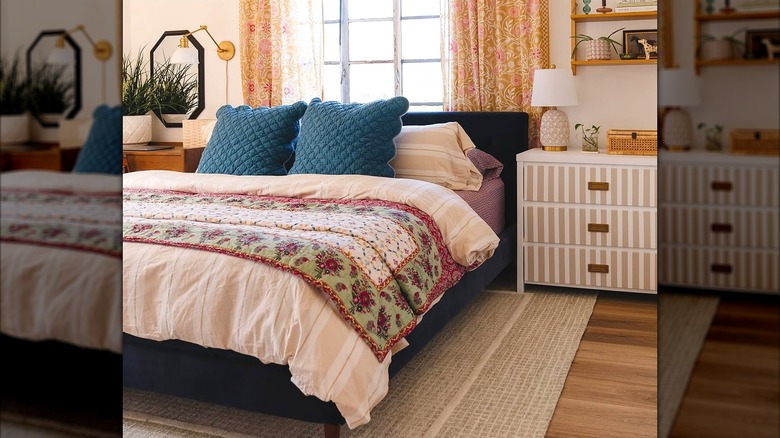 Cozy colorful bedding with striped duvet, floral comforter, and blue throw pillows