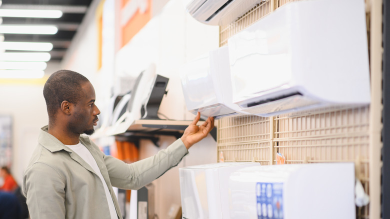 Man looking at different air conditioning units at the store