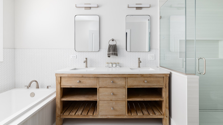 Modern wooden bathroom with a wood vanity, double sink, and mirrors