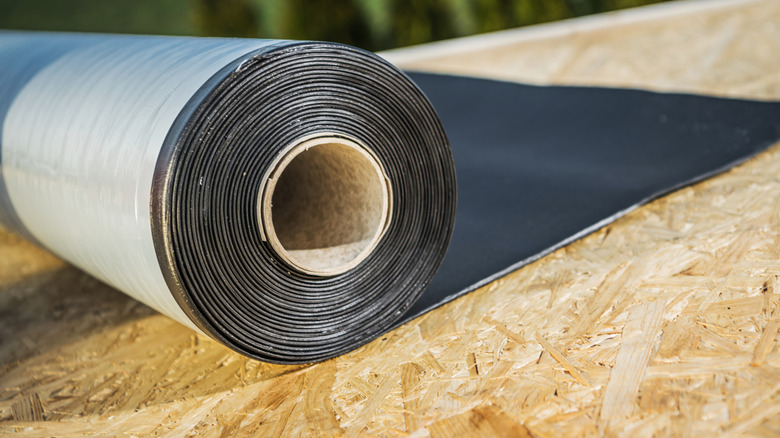 A roll of EPDM being unrolled onto roof