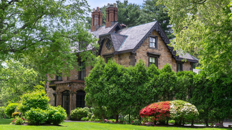 Gothic-style home with an elegant garden incorporating both formal and free-flowing plants