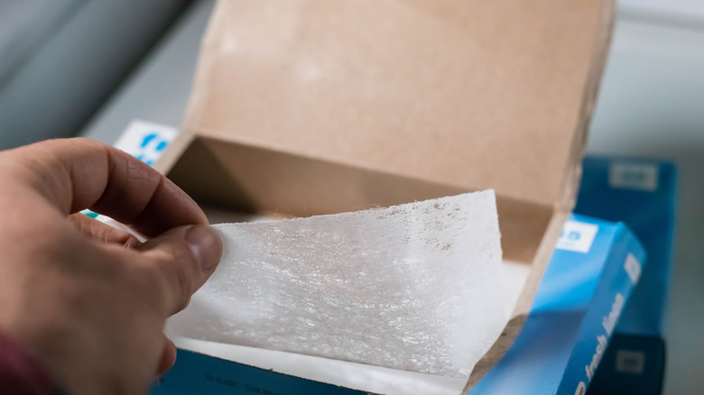 Person removing a dryer sheet