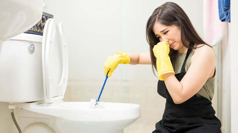 person covering nose in bathroom