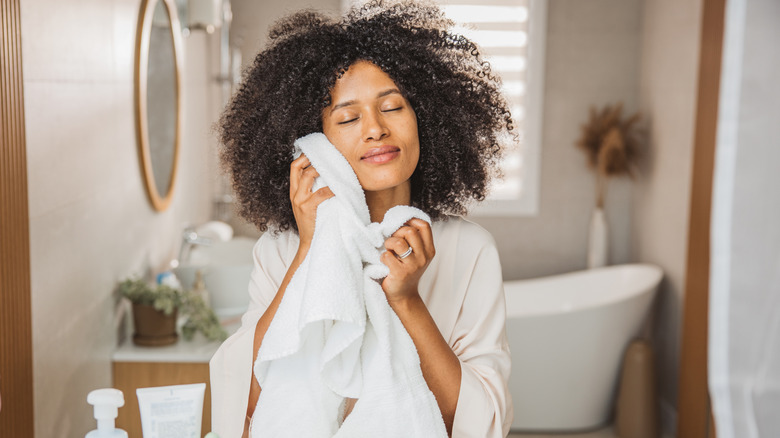 Woman pressing a soft towel to her cheek