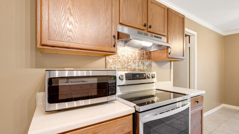A dated kitchen with honey oak cabinets.