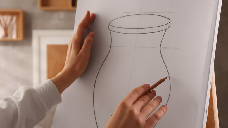 A person draws a vase on paper
