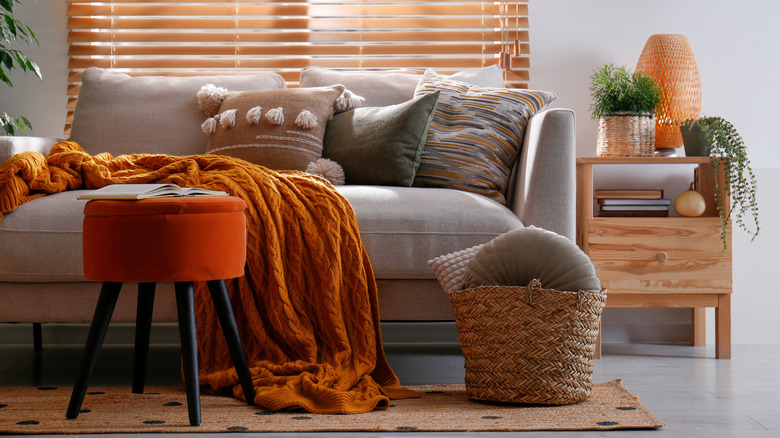 A deep orange throw blanket on a cozy couch