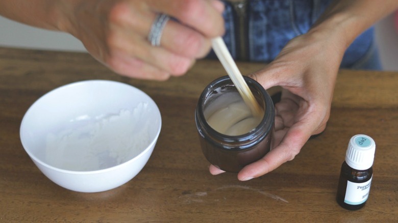 woman mixing baking soda paste in glass jar