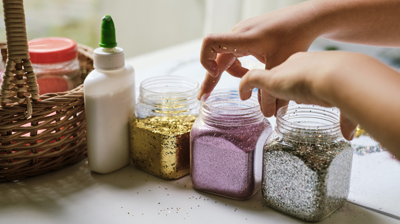 hand lifting container of glitter