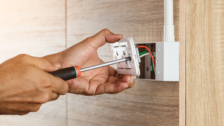 Screwing outlet into wall