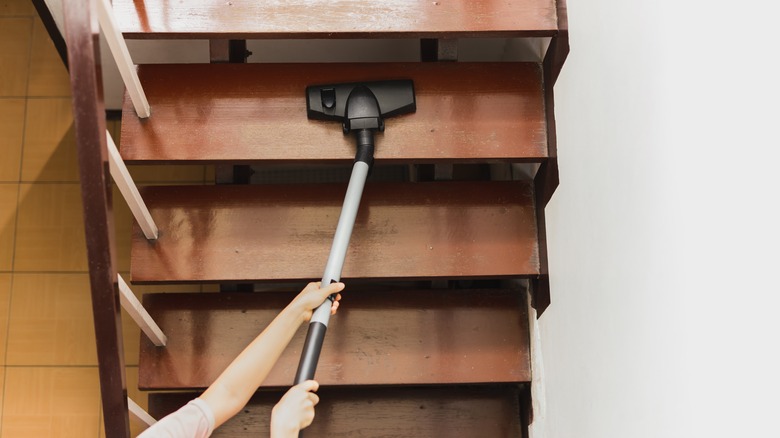 Person mopping wood staircase