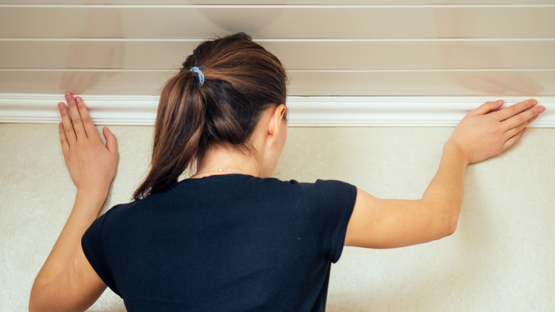 Woman installing crown molding