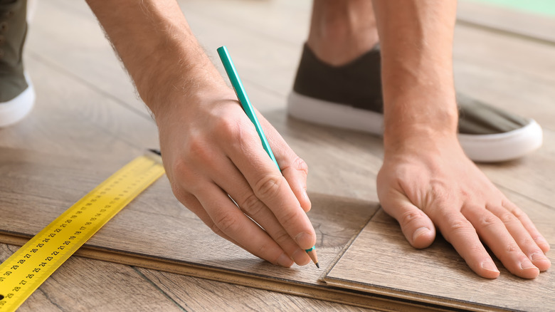 Person measuring laminate floors