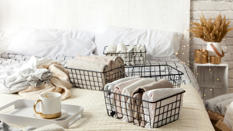 Container with clothes on bed 