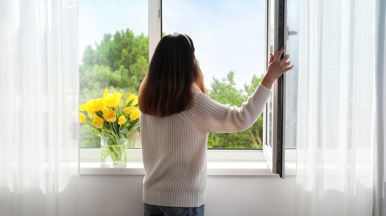 woman opening window