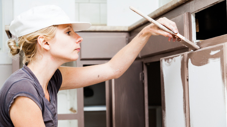 Person painting their kitchen cabinets