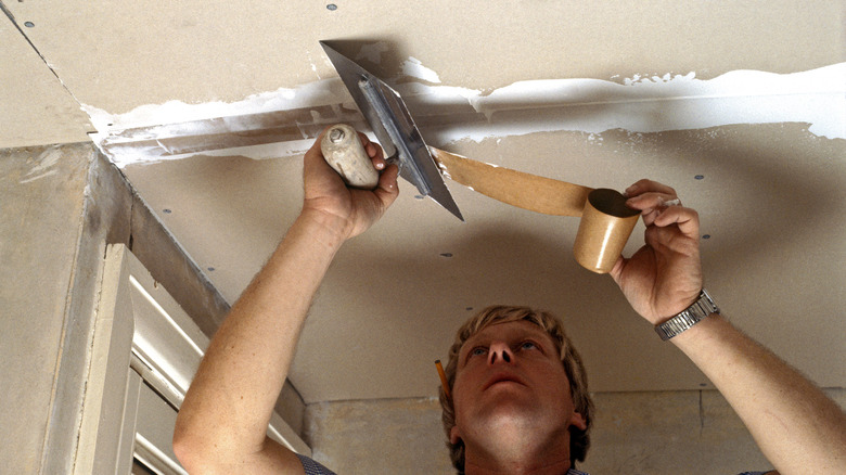 man fixing drywall cieling