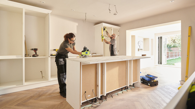 Contractors installing kitchen cabinets