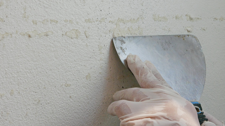 Person removing glue from wall