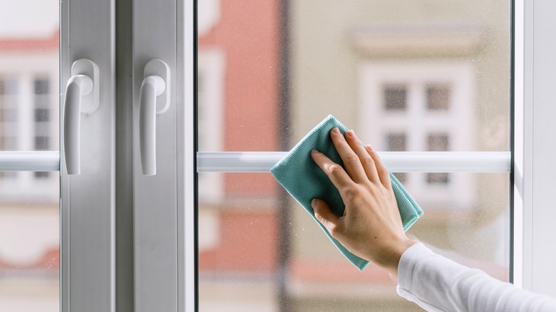 Woman's hand wiping a clean window