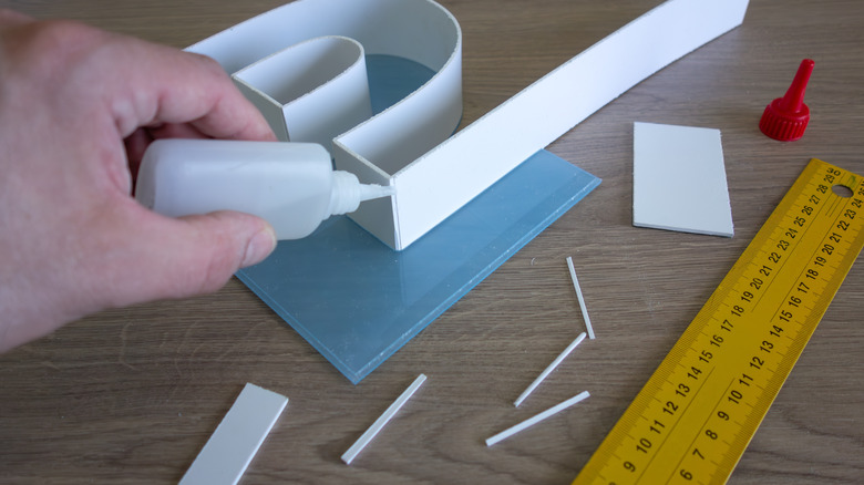 hand of a person gluing pieces of material together