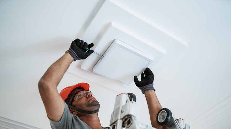 Person installing ceiling light