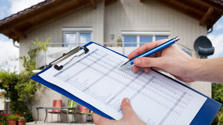 Home assessor appraising house