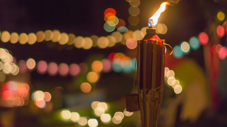 tiki torch in front of colorful background